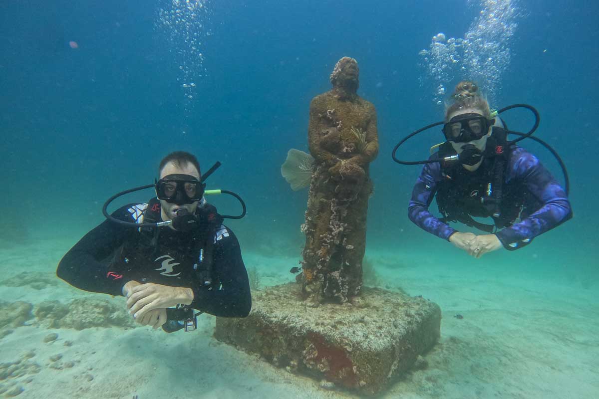 Bailey and Daniel pose for a photo at the MUSA underwater museum while scuba diving in Cancun, Mexico