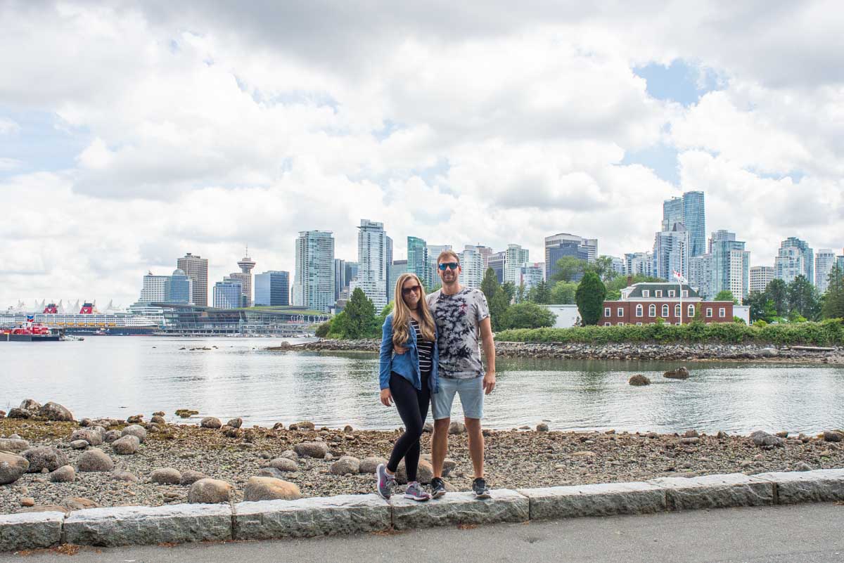 Daniel and Bailey pose for a photo with Vancouver in the background in Stanley Park