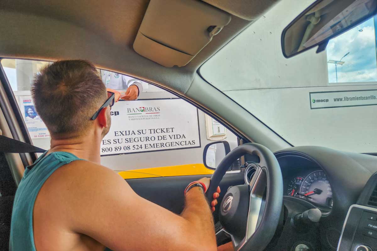 Paying a toll booth in our rental car in Mexico
