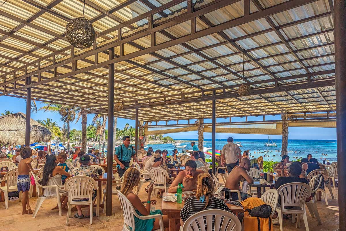 People sit a a restaurant at Akumal Beach in Mexico
