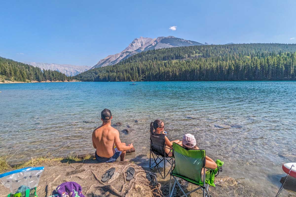 A groupd of people relax in the water at Two Jack Lake, Canada