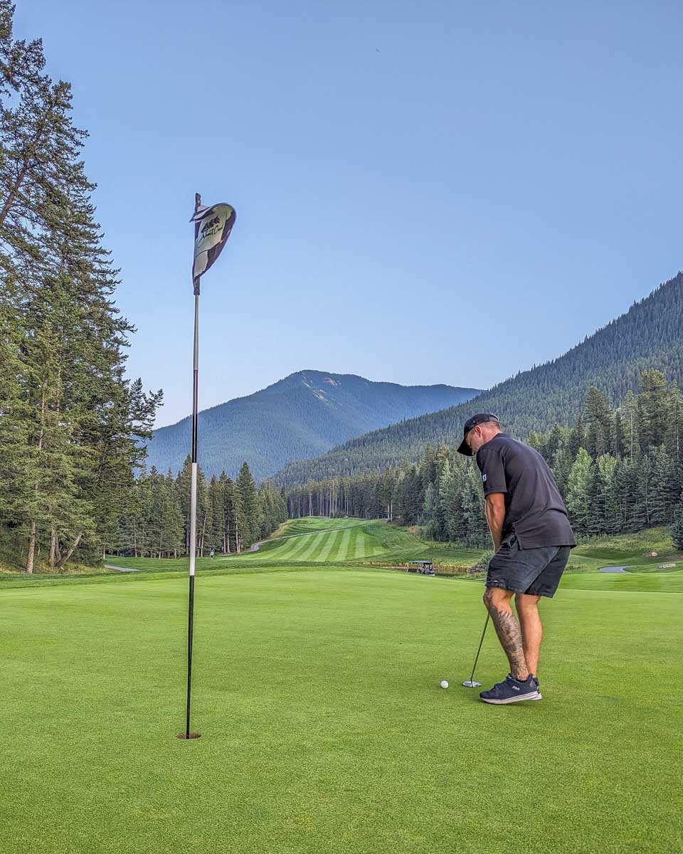 A man puts a ball at Stewart Creek Golf Course in Banff