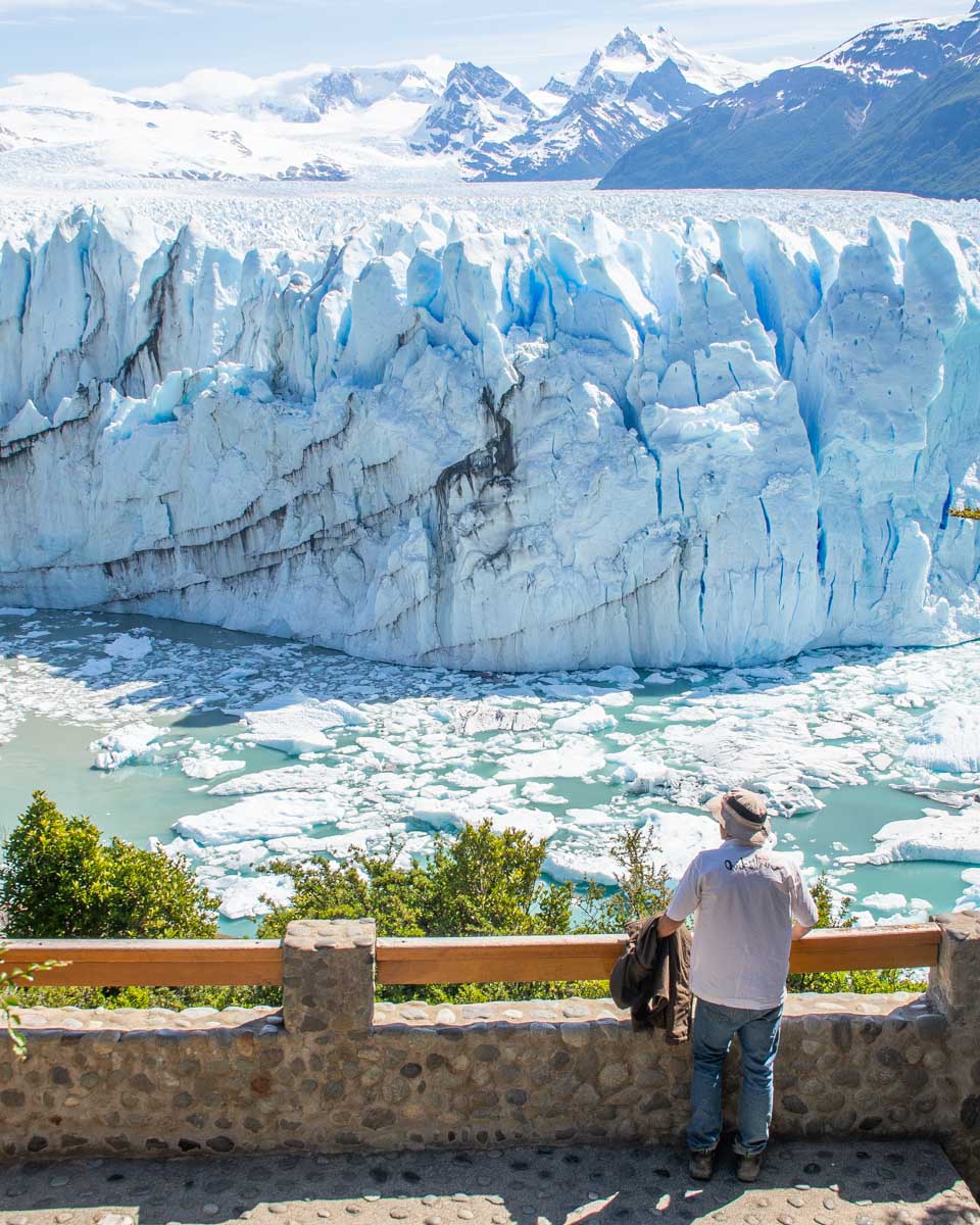 A man stands on the Perito Moreno Glacier boardwalk and watches the glacier