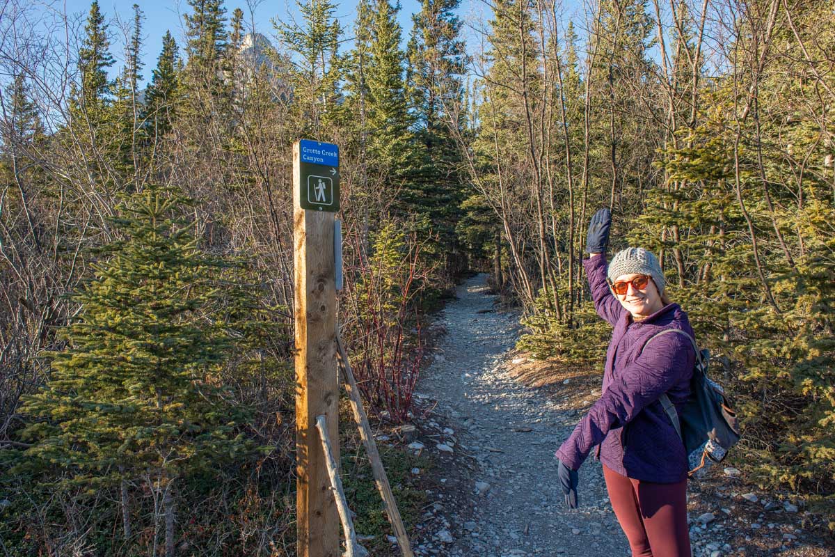 Bailey walks past a sign pointing to Grotto Canyon near Canmore, Alberta