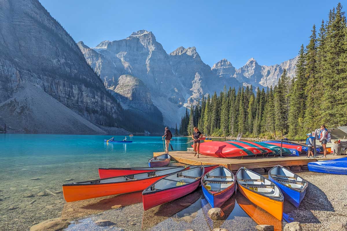 Canoes sit in the water at Moraine Lake, Banff National Park
