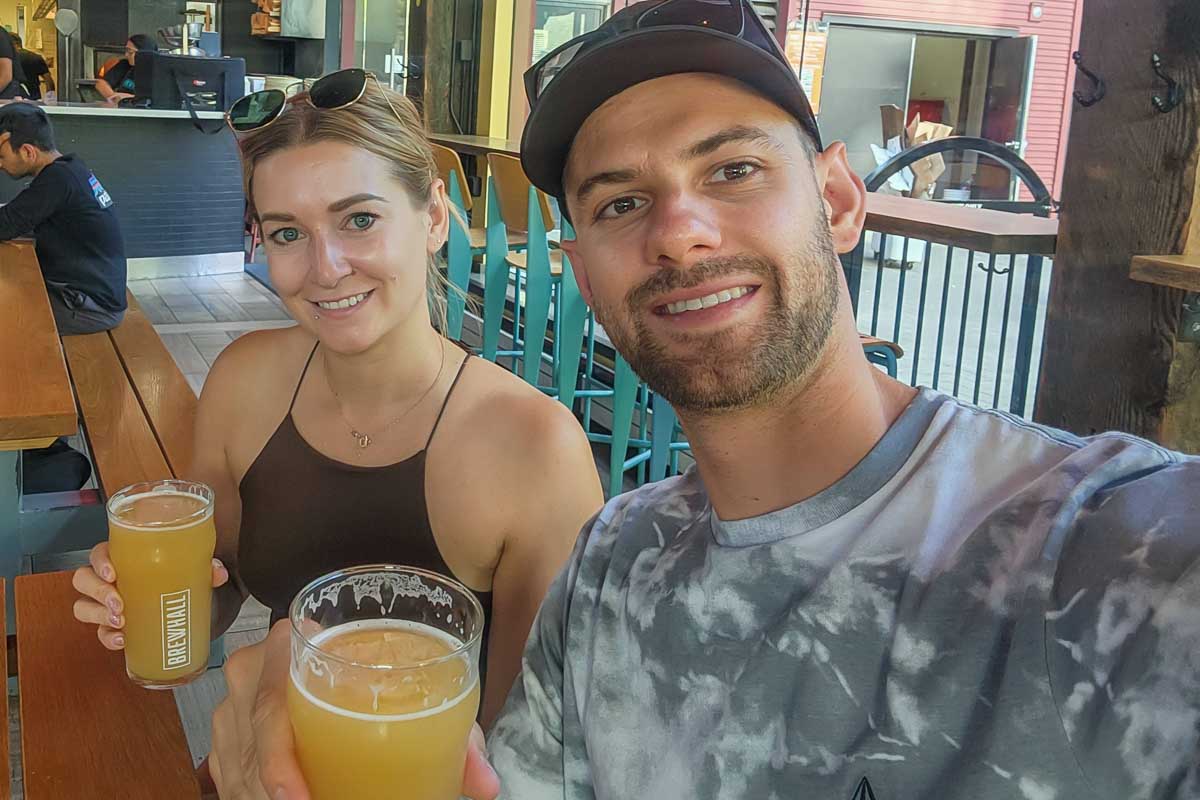 selfie of Bailey and Daniel drinking craft beer at a brewery in Calgary
