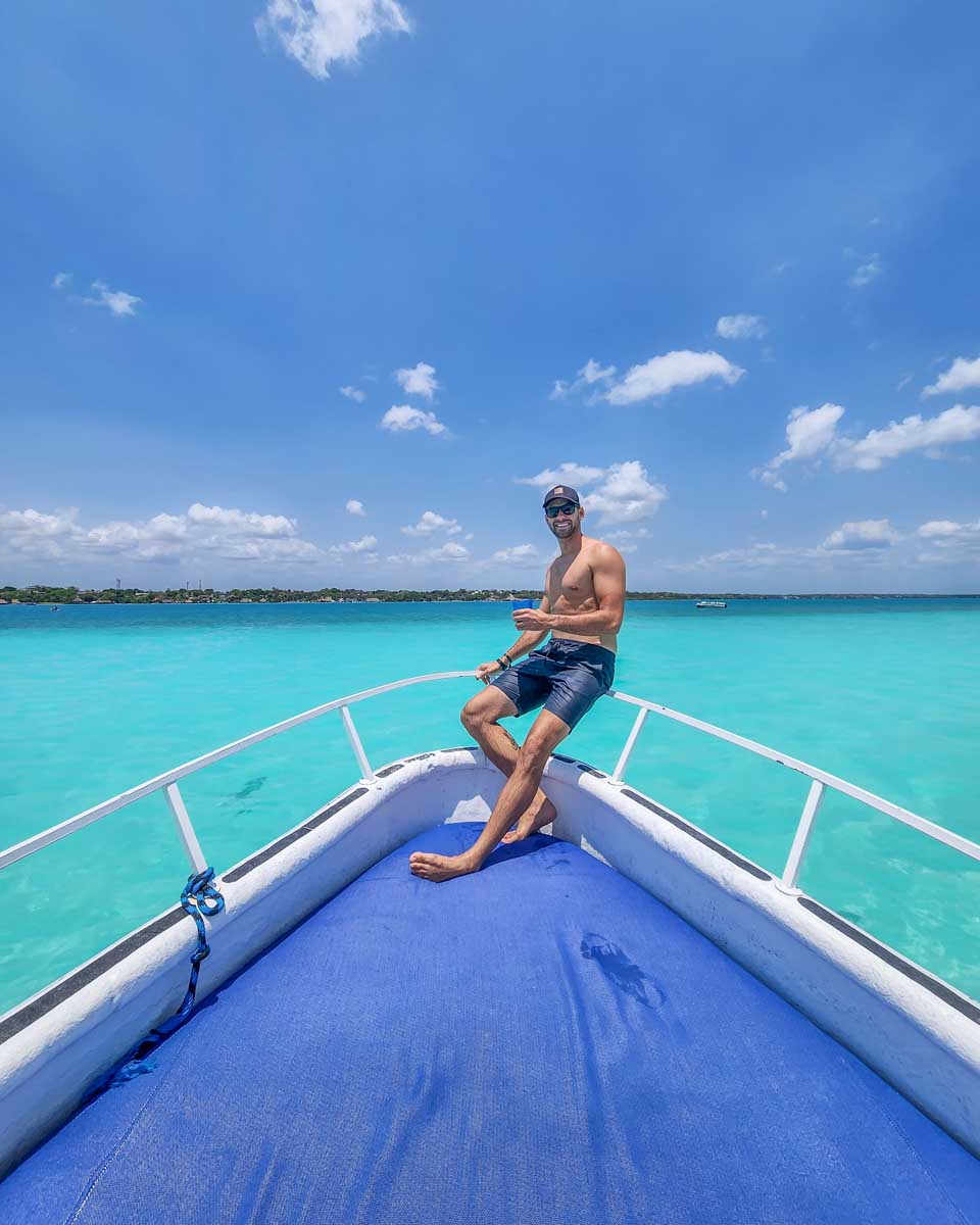 Daniel on the front of the boat soaking up the sun on a bot tour in Bacalar, Mexico