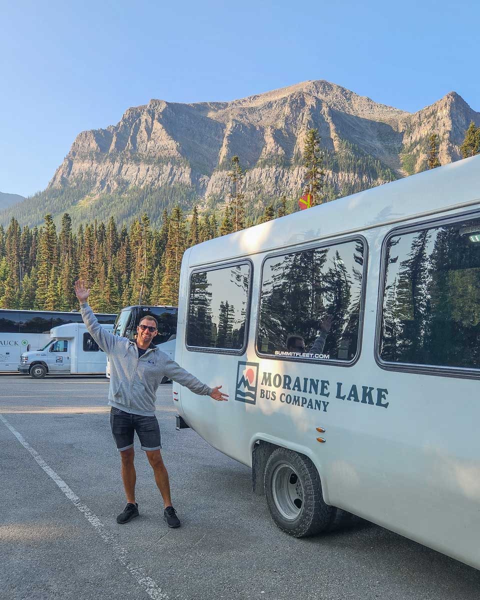 Daniel poses with a shuttle bus at Lake Louise