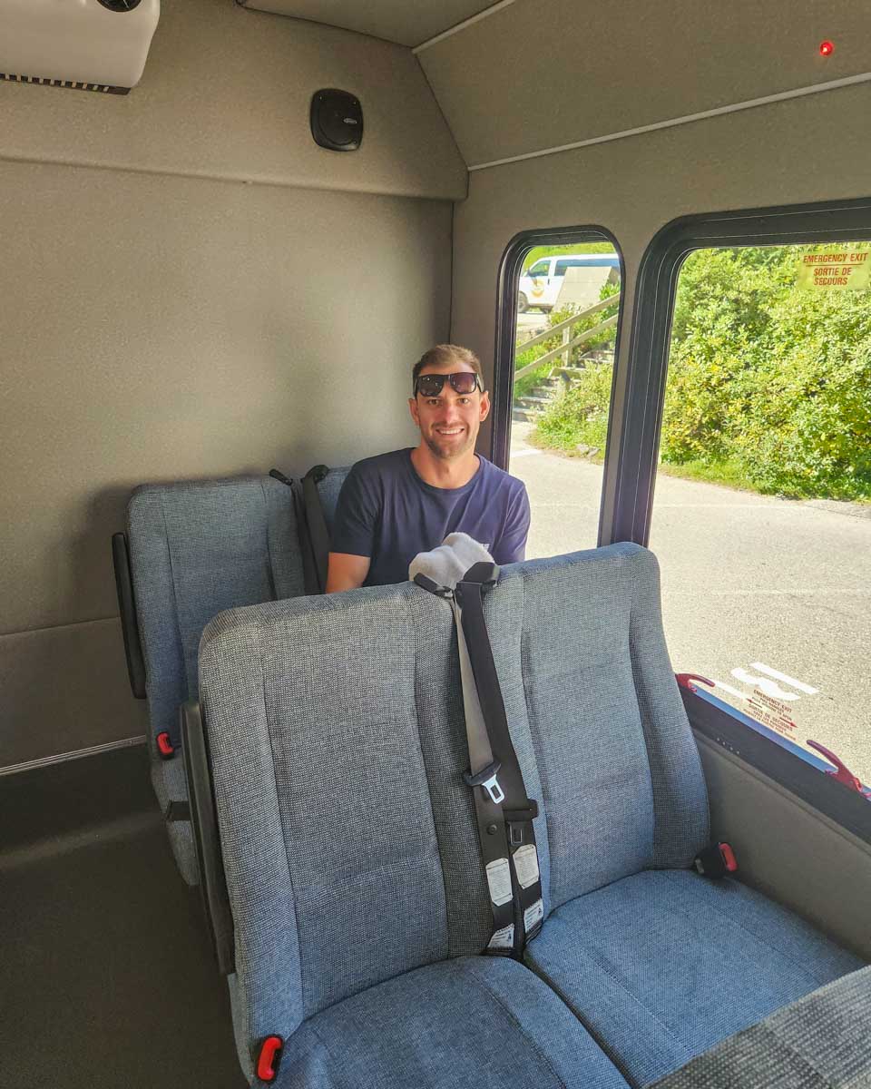 Daniel sits on a Moraine Lake bus company shuttle on his way to Moraine Lake