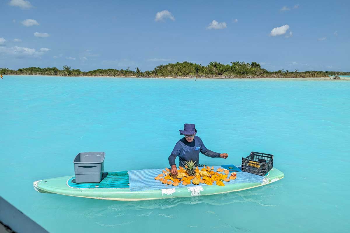 Food from our Bacalar boat tour on a surfboard in the water of Bacalar Lagoon, Mexico