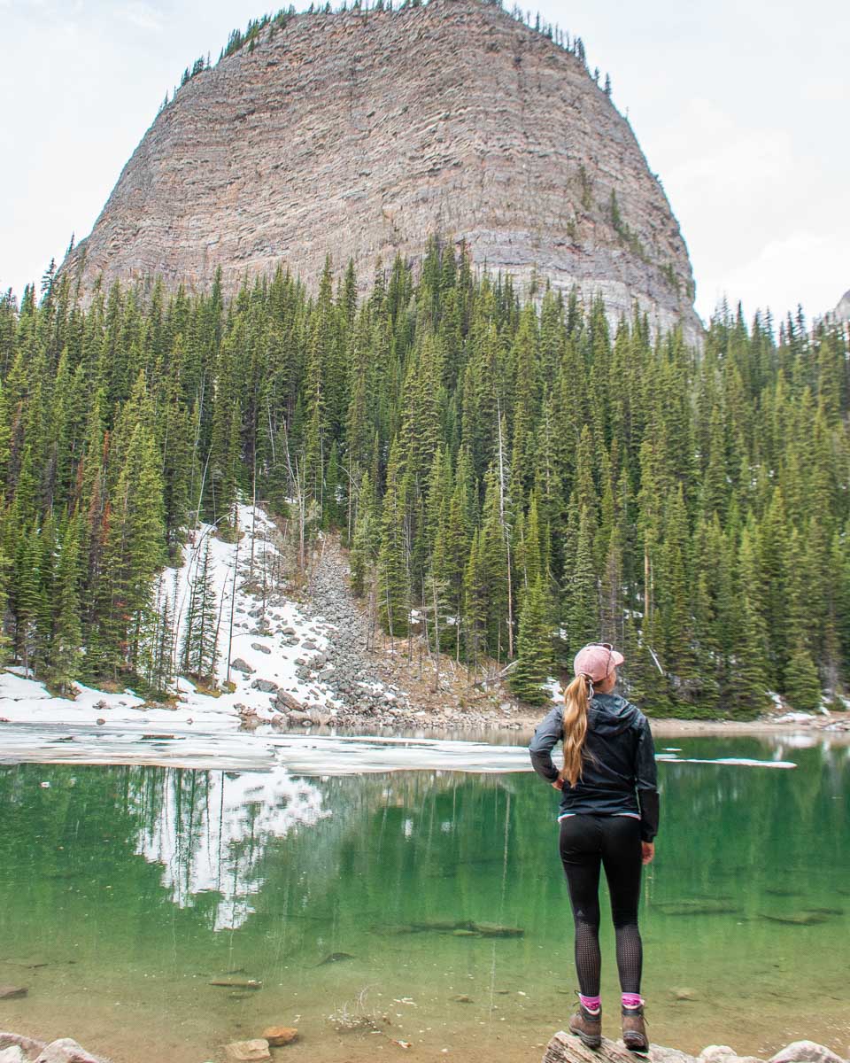 bailey stands at the edge of Mirror Lake with Big beehive in the backgorund near lake louise