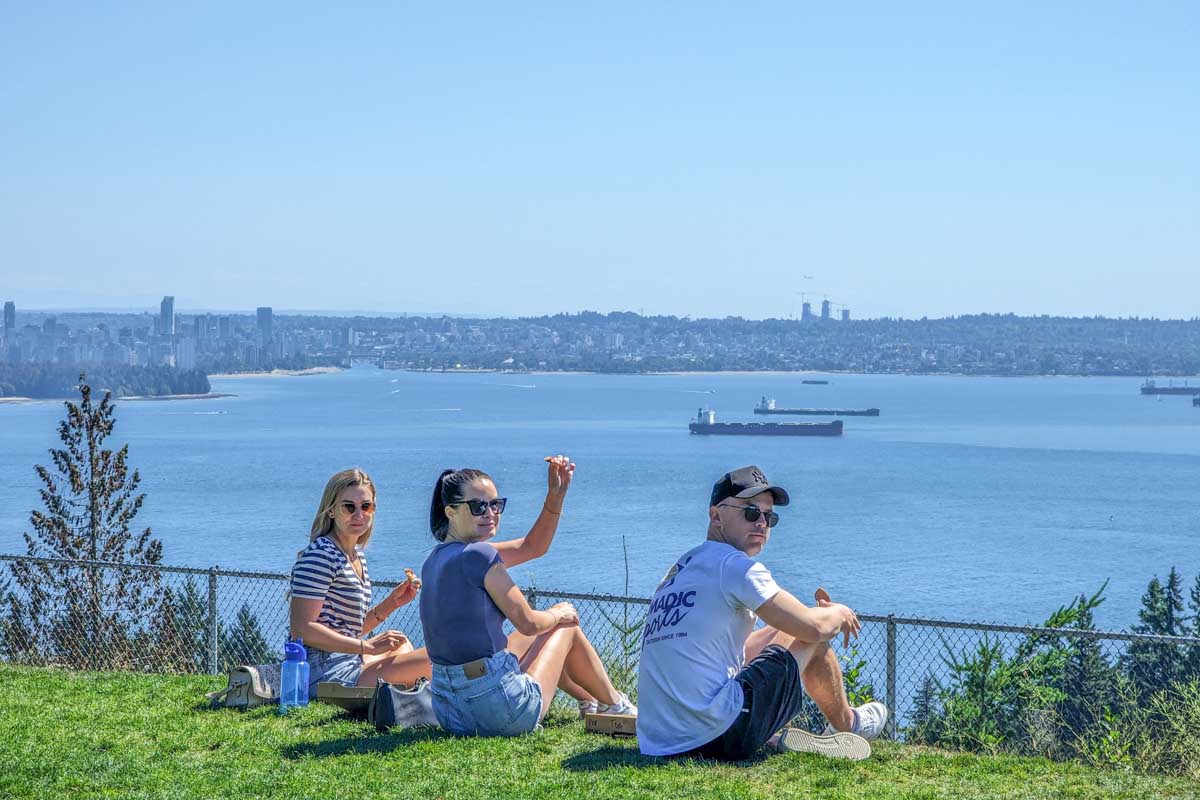 Three people enjoy pizza at Cypress Pop-Up Village in Vancouver