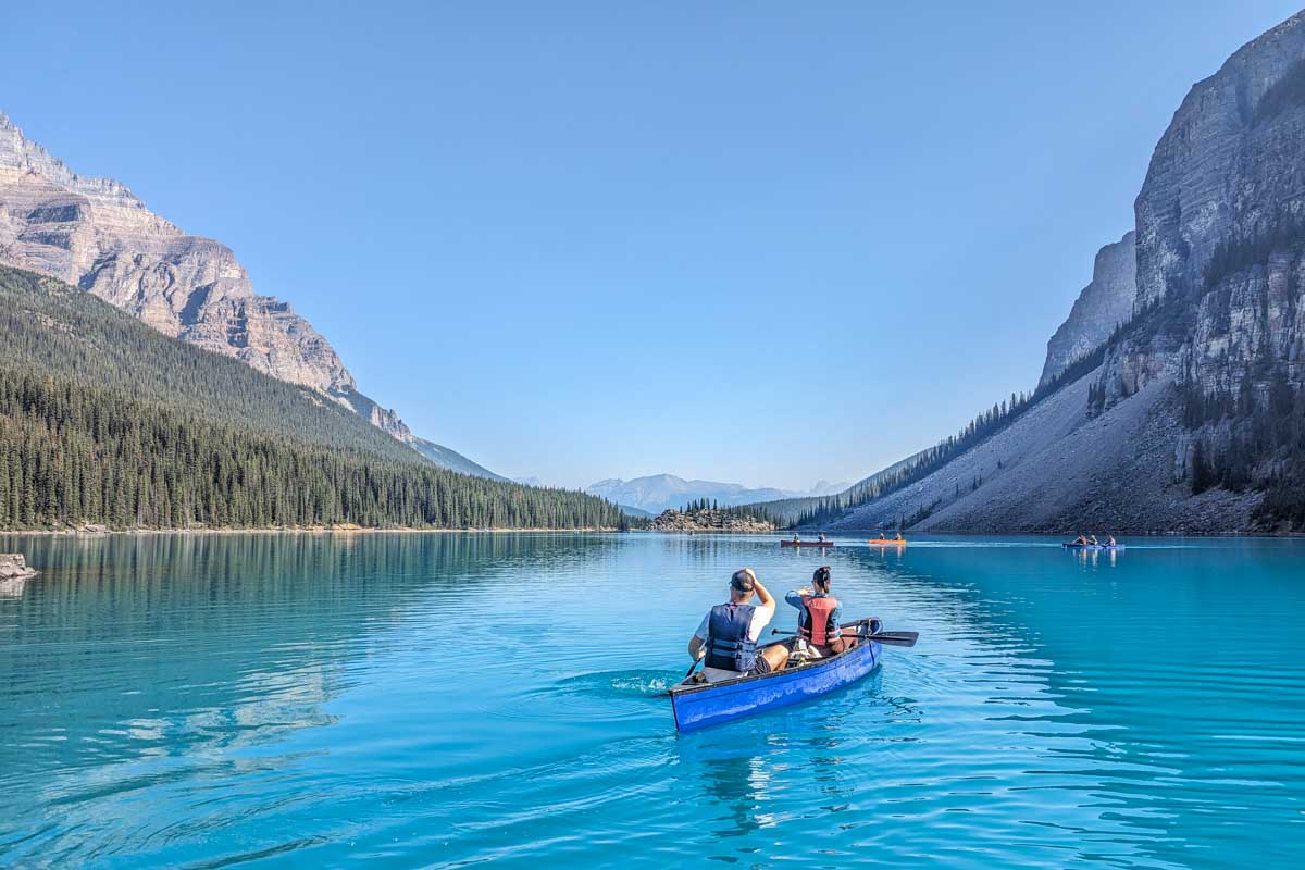 Two people canoe in Moraine Lake on a beautiful day