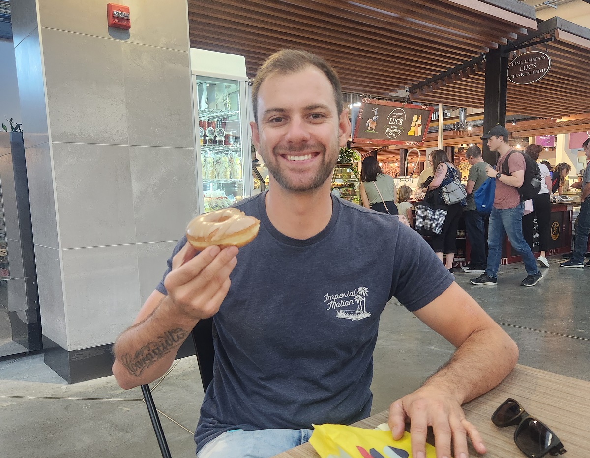 daniel eats a donut at the calgary market
