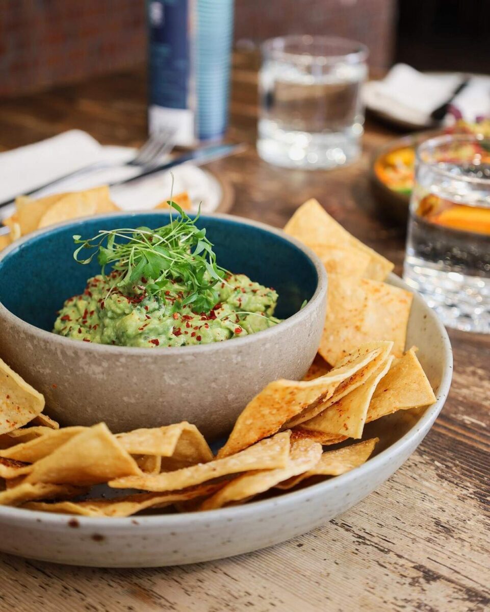 a bowl of Guacamole and chips from The Coup in Calgary