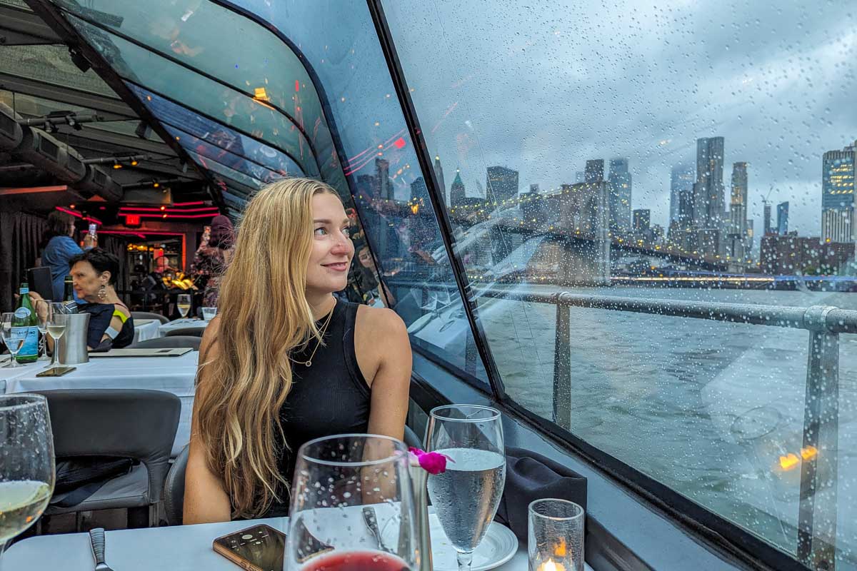 Bailey looks out the window on the Bateaux New York Premier Dinner Cruise and admires the view of the city skyline