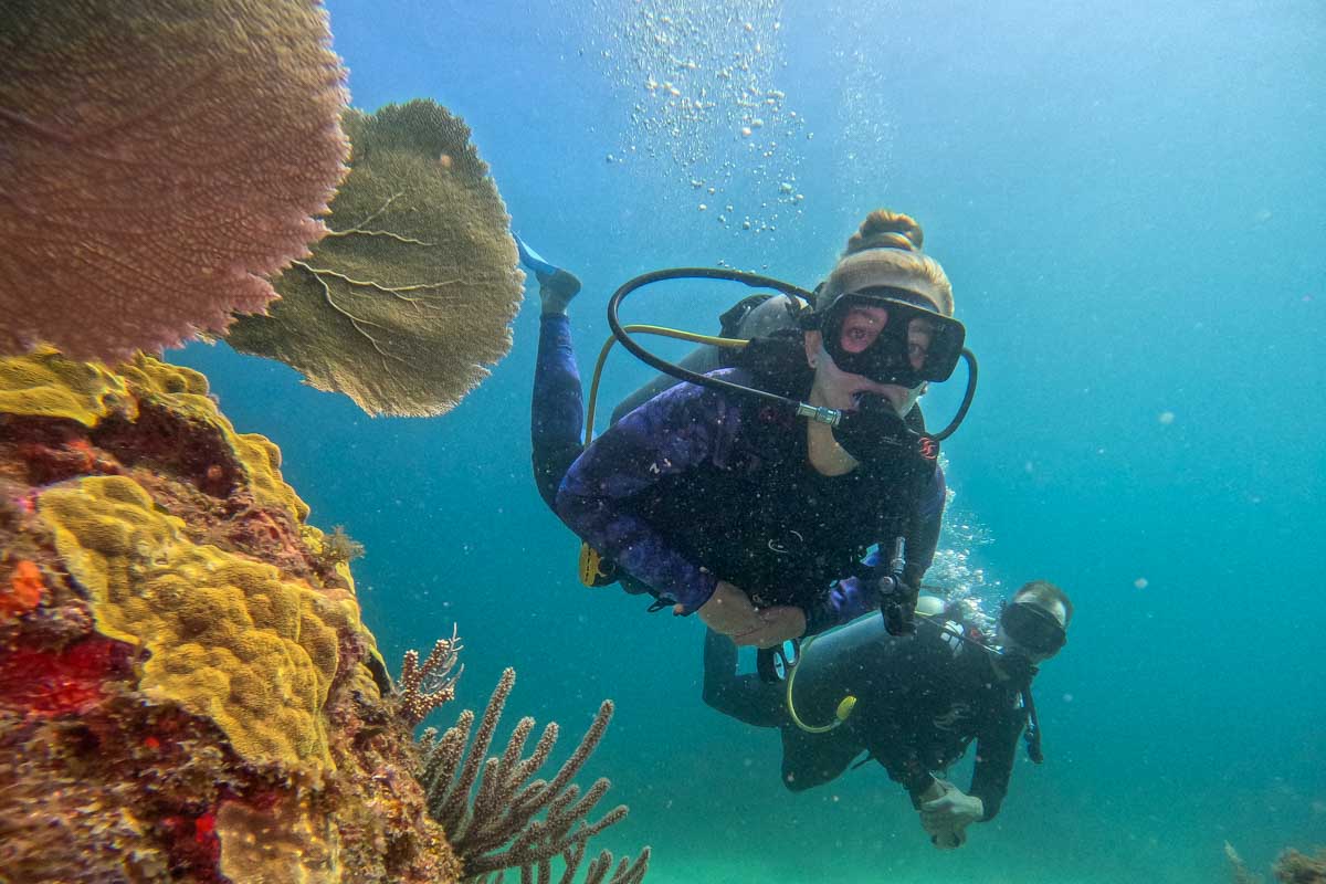 Daniel and Bailey swim past some corals while scuba diving in Playa Del Carmen, Mexico