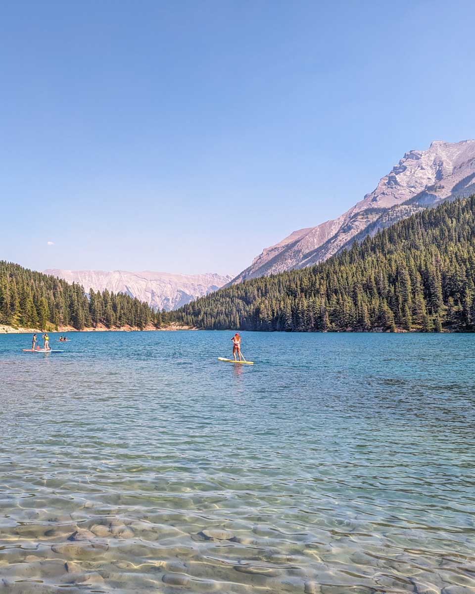 People enjoy water sports on Two Jack Lake in Banff as seen from the lake trail