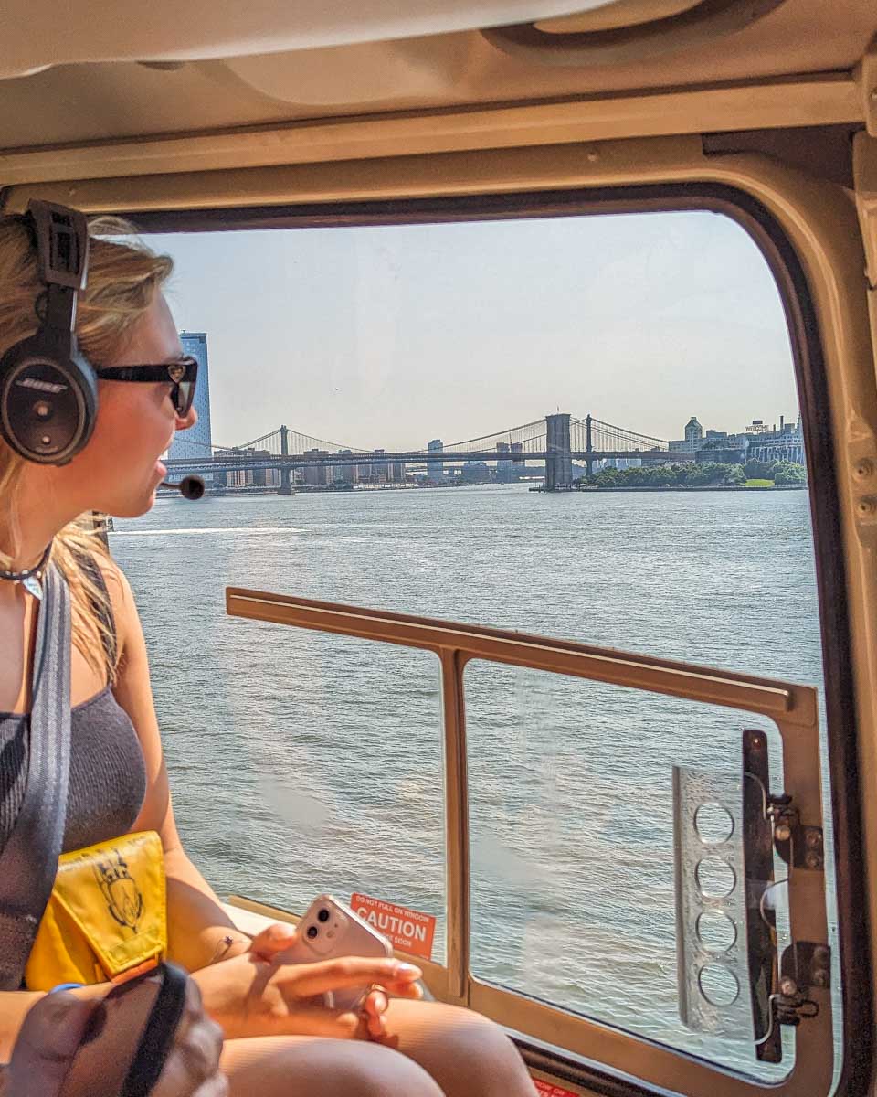 A lady looks out the window of a helicopter in New York City