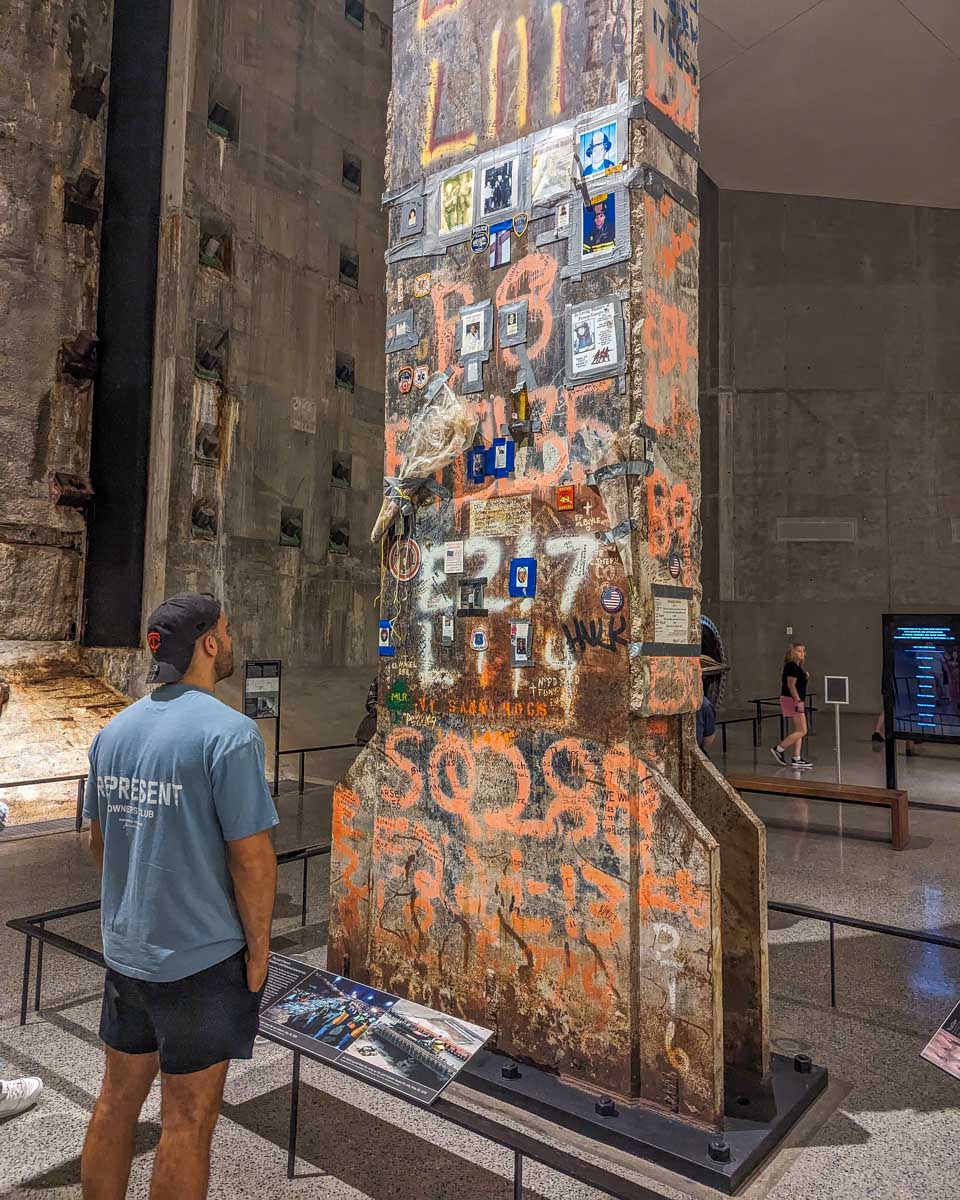 A man looks at a metal beam inside the 911 Memorial and Museum in NYC