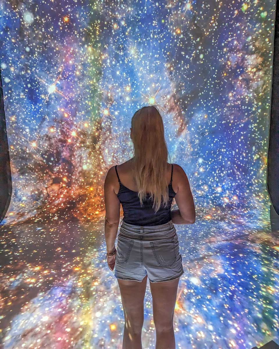 Bailey looks at a galaxy at Mystika Immersive, Tulum