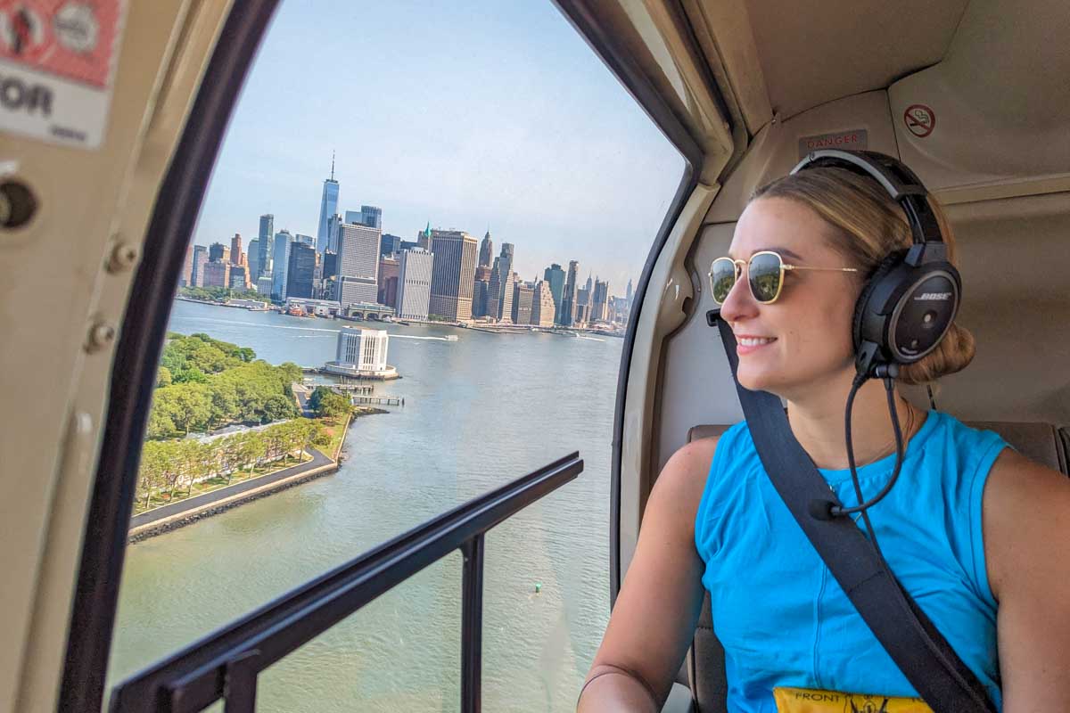 Bailey looks out the window of our helicopter on ascenic helicopter ride in New York City with views of Ellis Island and Manhattan