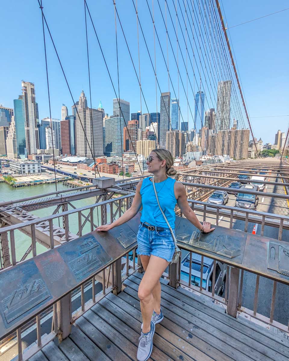 Bailey poses for a photo along the Brooklyn Bridge in New York City with Manhattan in the background