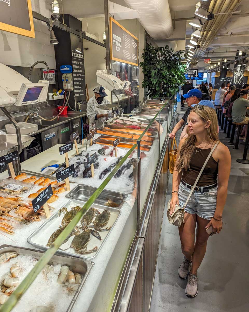 Bailey walks the fresh seafood section inside the Chelsea Market in NYC during free time on our food tour