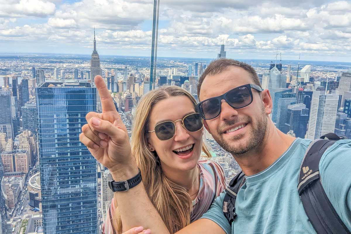 Daniel and Bailey take a selfie on the Edge NYC with the Empire State Building in the background