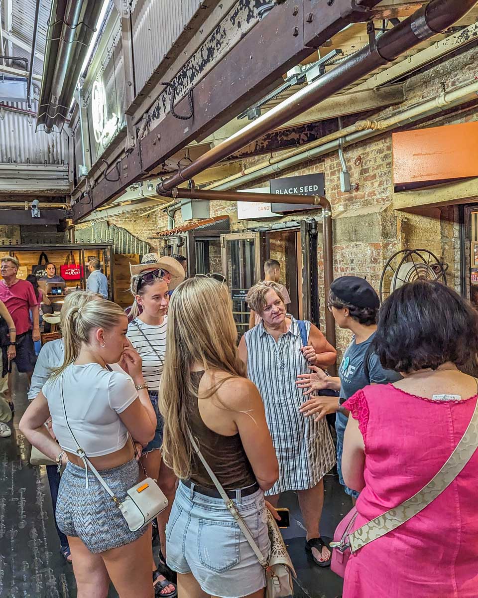 Our food tour guide talks to our group in the Chelsea Market in NYC