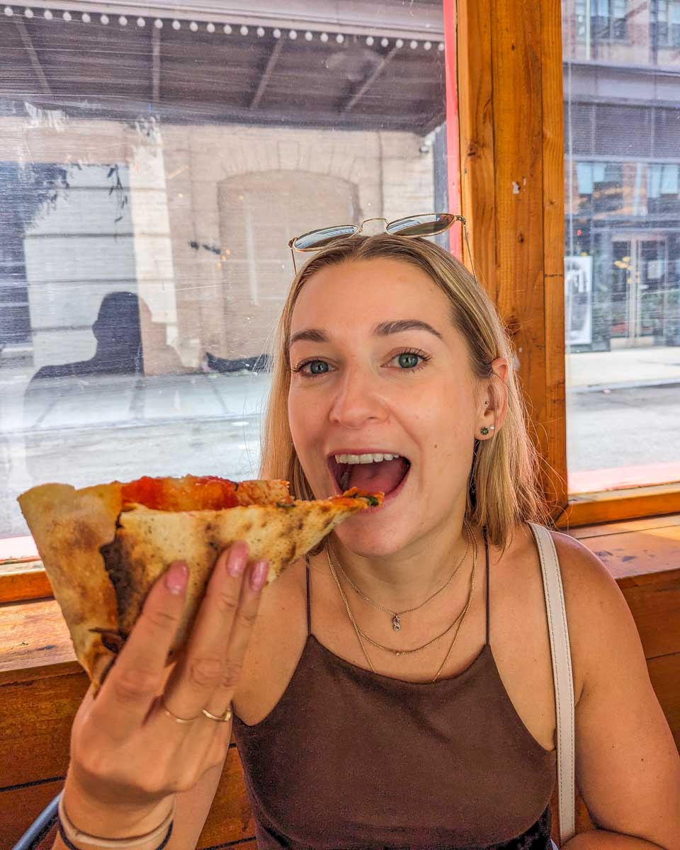Bailey eats a New York Slice on a food tour at the Chelsea Market