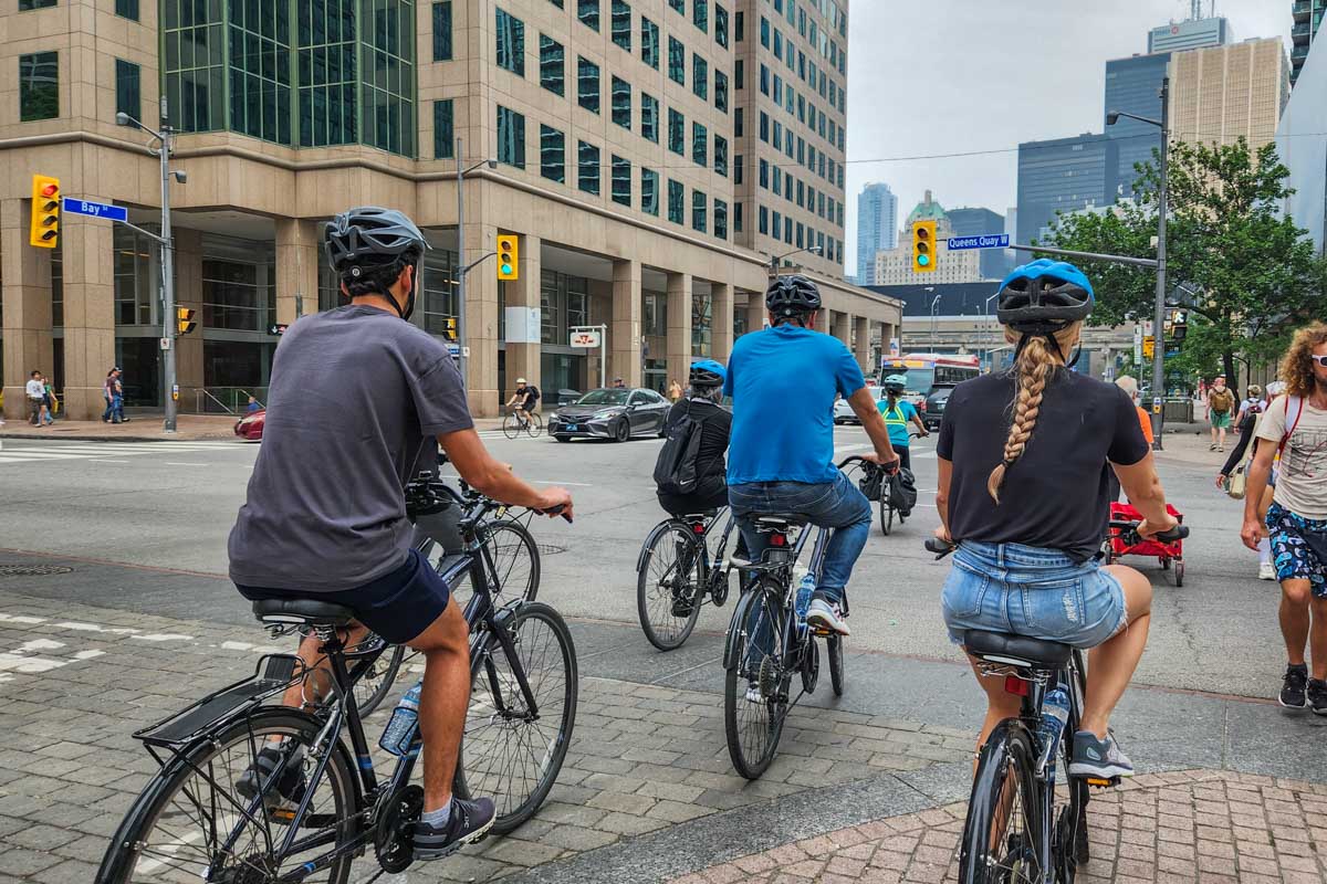 A group of people ride bikes through Toronto on a tour
