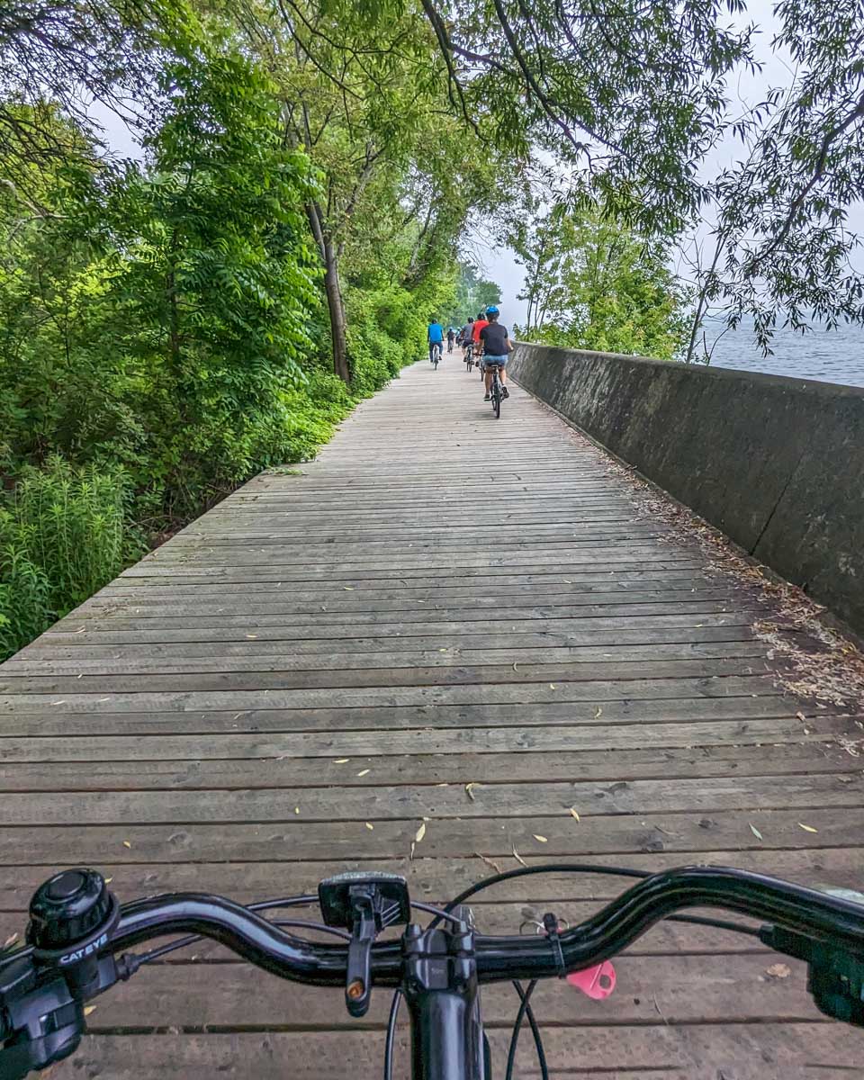 Bailey rides a bike along the lake wall on Toronto Island on a tour in Toronto
