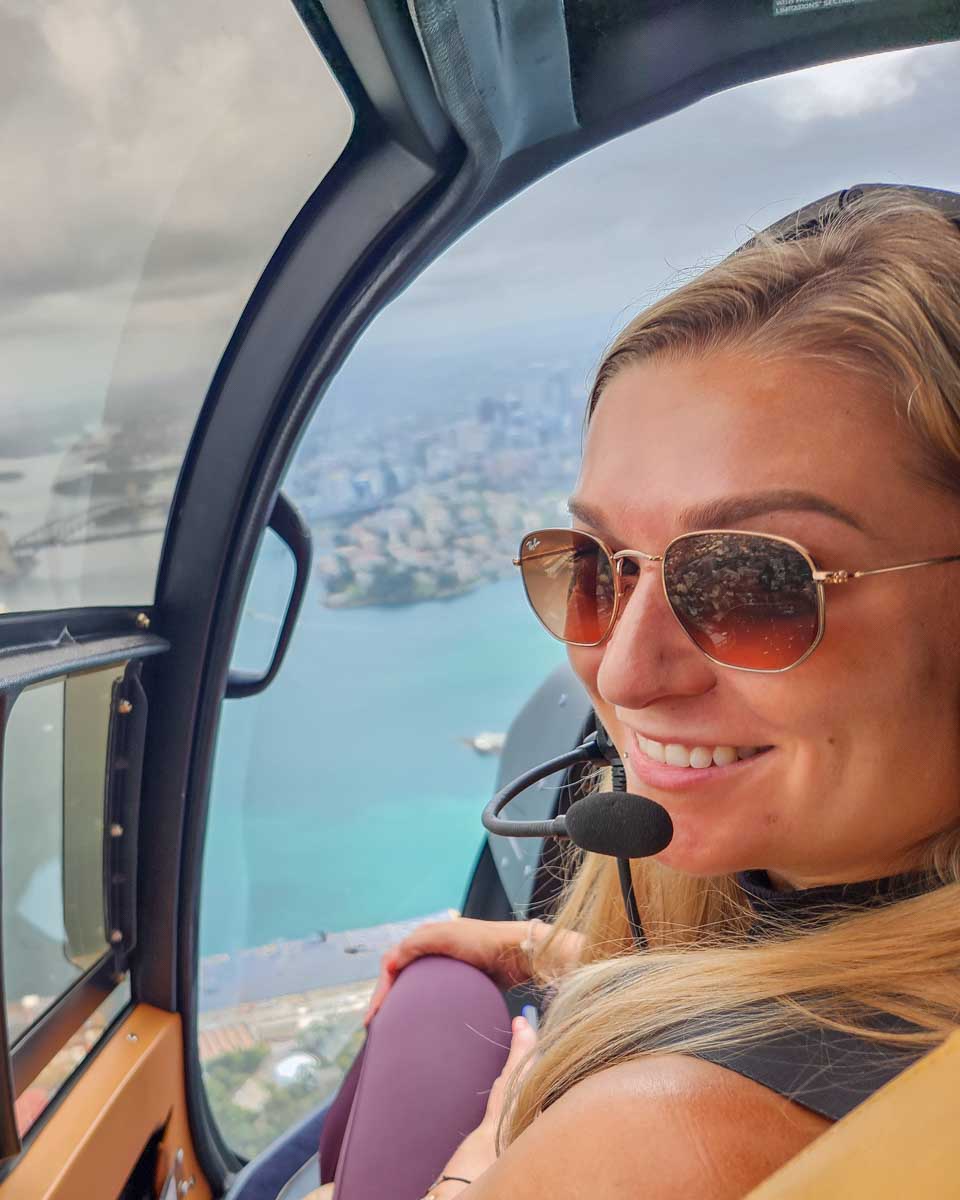 Bailey smiles at the camera while on a helicopter tour in Sydney, Australia