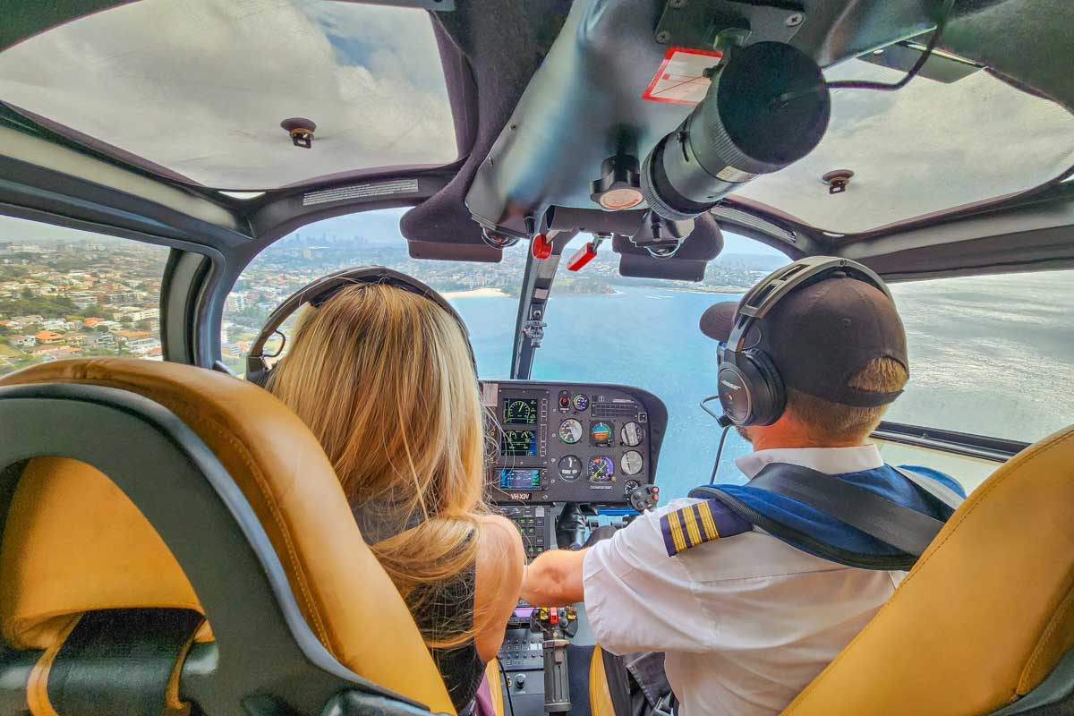 View of the two people in the front seat of a helicopter while on a scenic flight over Sydney