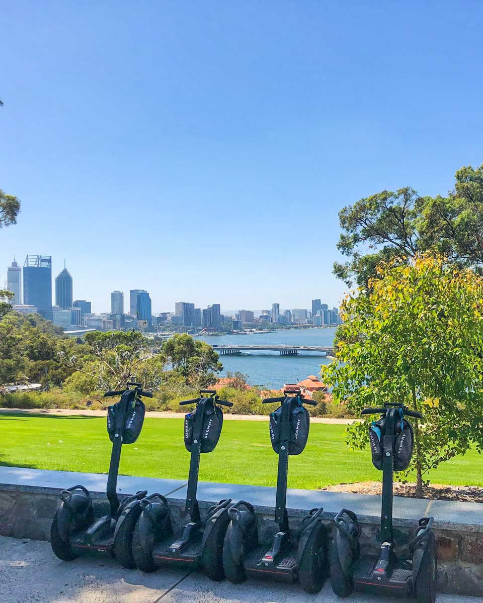 A group of segways lean against a wall on a tour in Kings Park, Perth