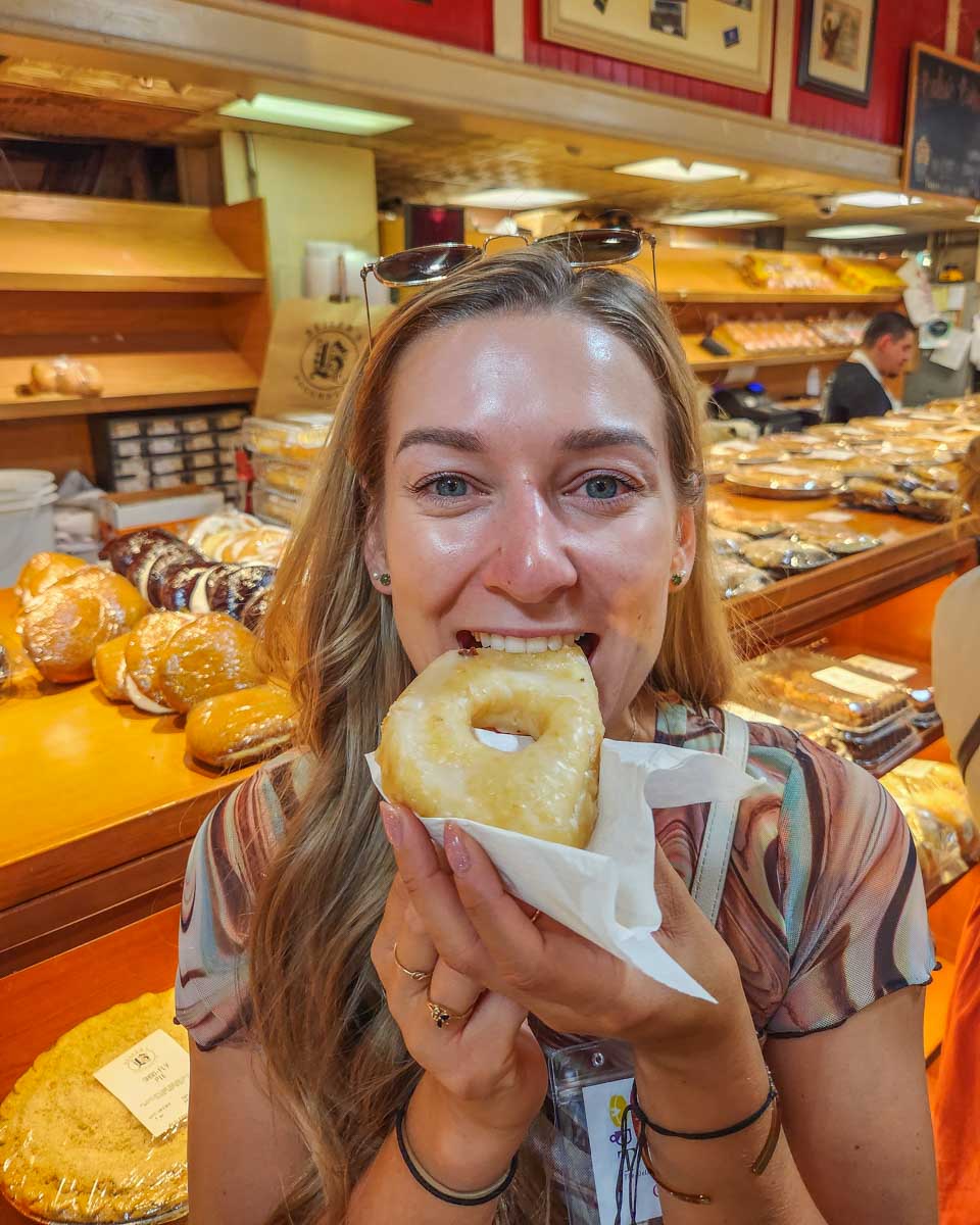 Bailey bites into a doughnut during our food tour in Philadelphia