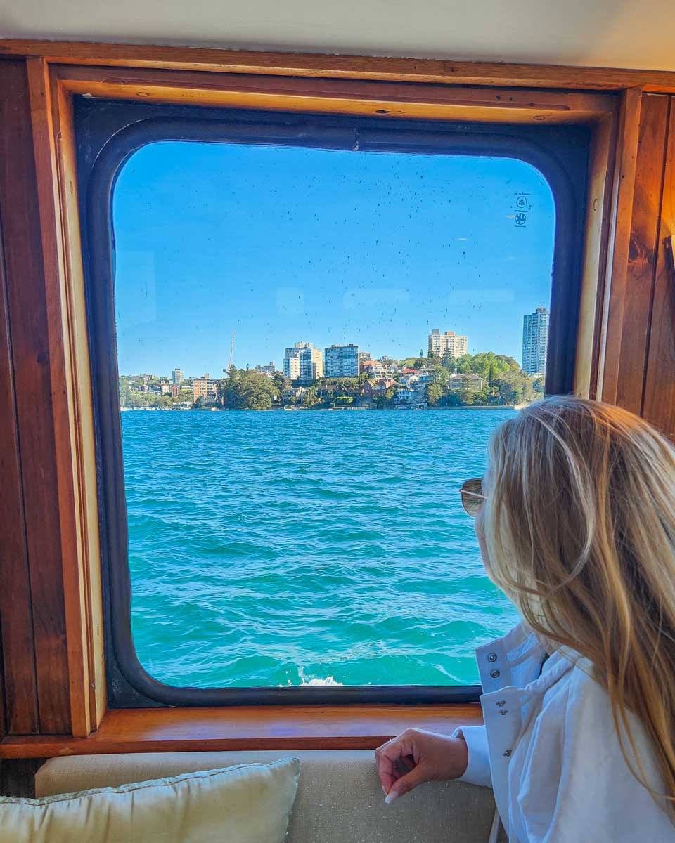 Bailey looks out the window on a Sydney Harbour Cruise with views of the city