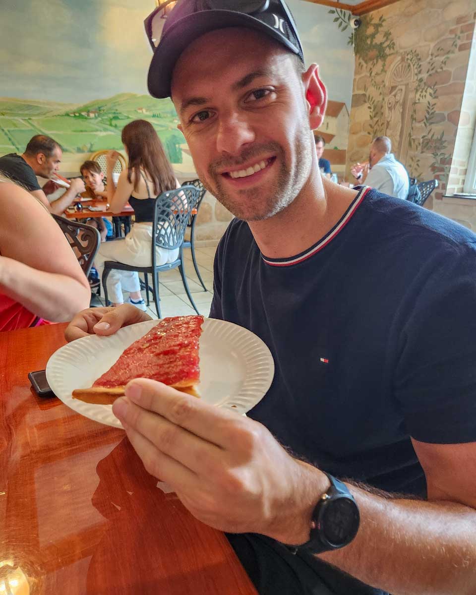 Daniel with a slice of Tomato Pie that he got to try on a walking food tour around Philadelphia, USA