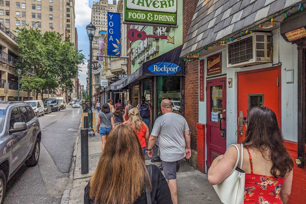 Our food tour group follow our tour guide down the street in Philadelphia during a food tour