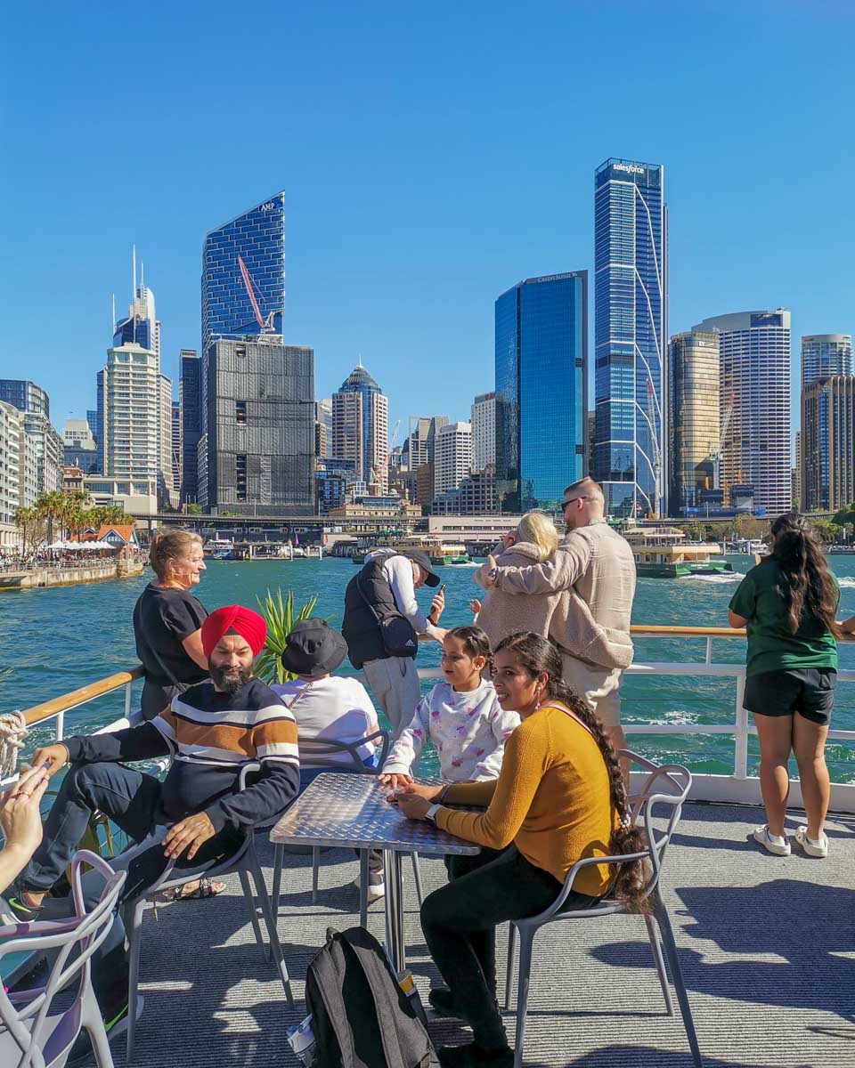 People enjoy the back deck of a Sydney Harbour cruise