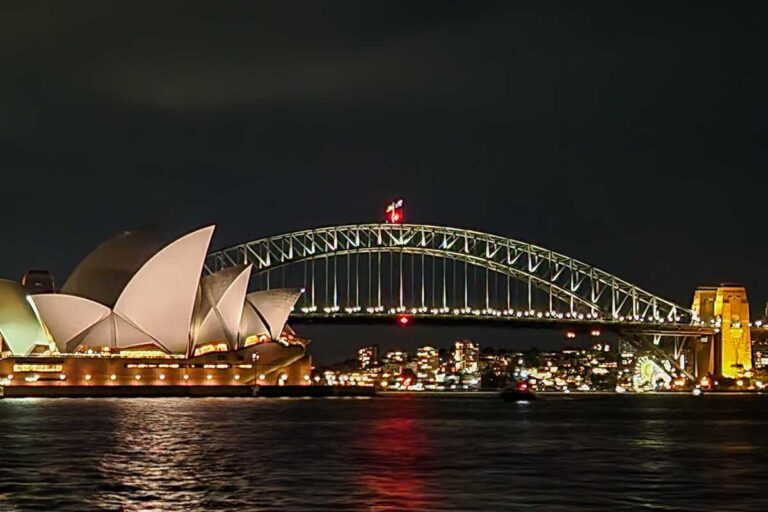 The Sydney Harbour Bridge and Sydney Opera House lit up at night from the Journey Beyond the Cruise Sydney dinner cruise