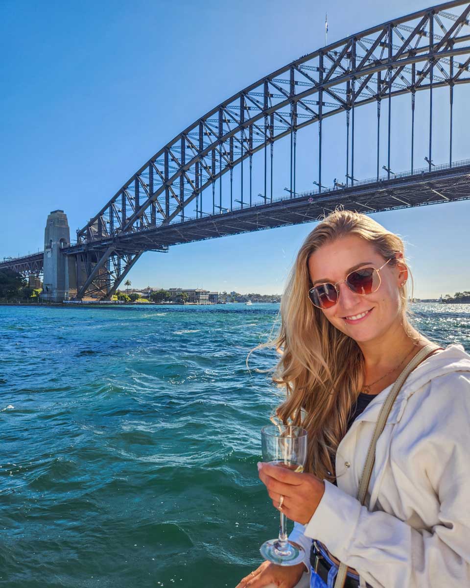 bailey enjoys a glass of wine as a our boat travels underneath the Sydney Harbour Bridge on a Sydney Harbour Cruise