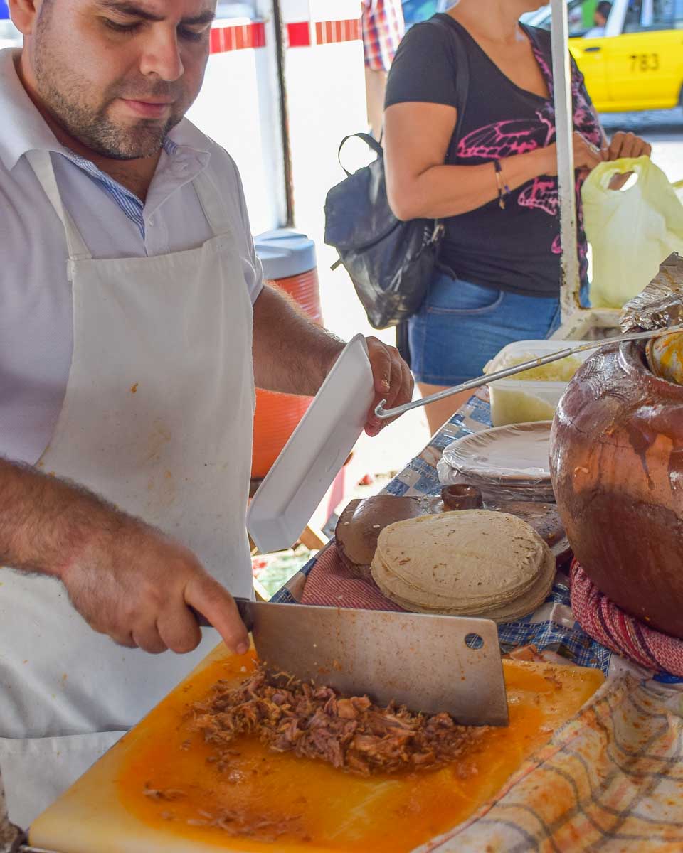 A man chops meat for tacos in Playa del Carmen, Mexico on a food tour