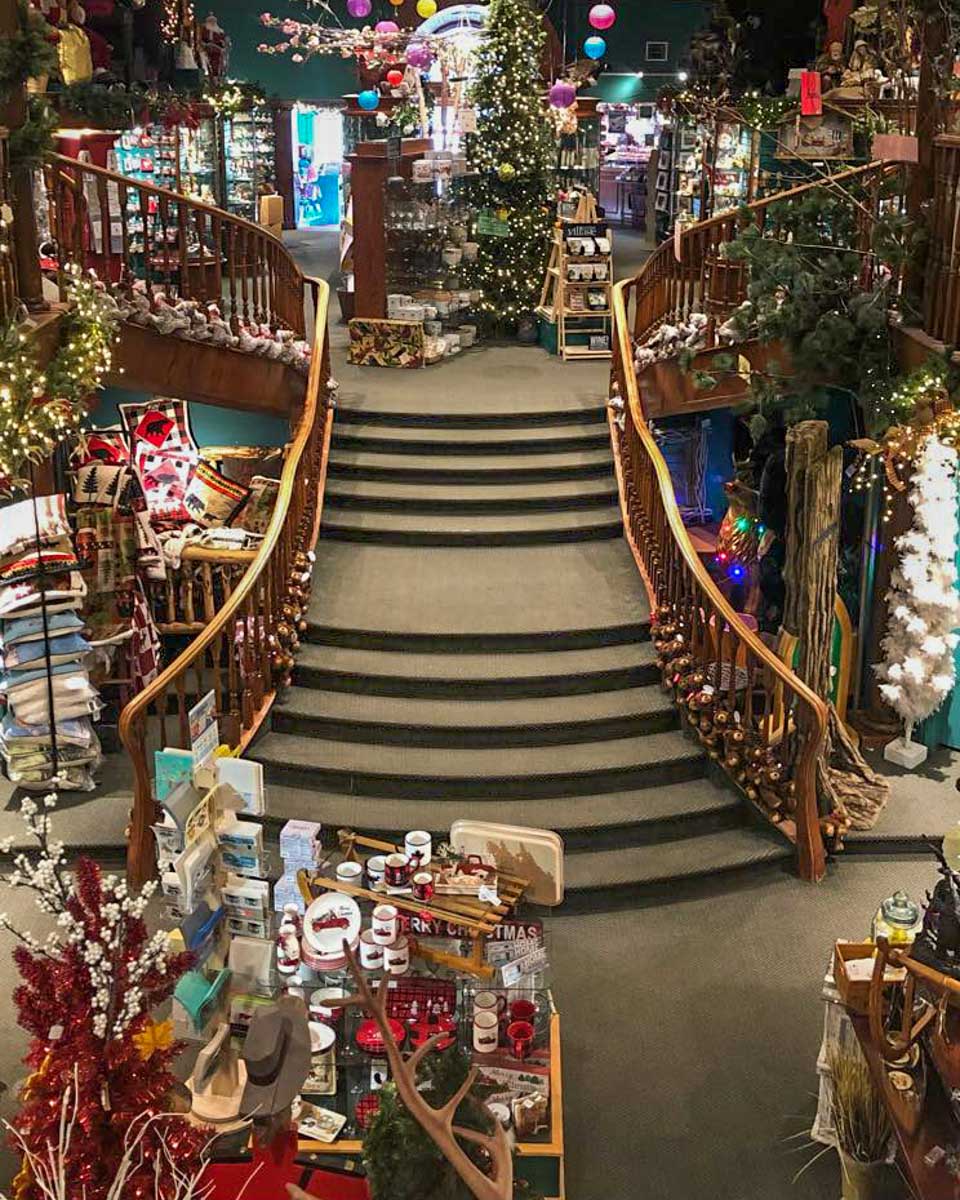 a large staircase inside the Spirit of Christmas store with tons of decorations around