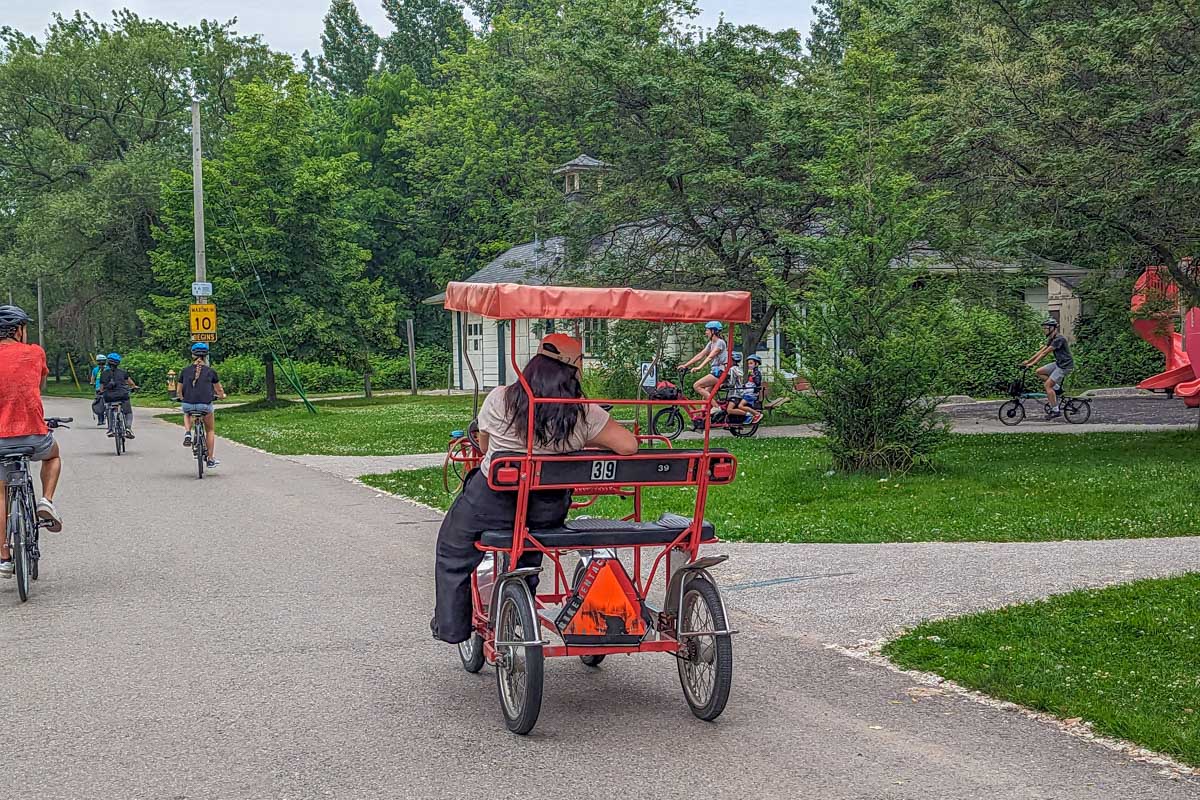 A lady rides a pedi bike on the Toronto Islands