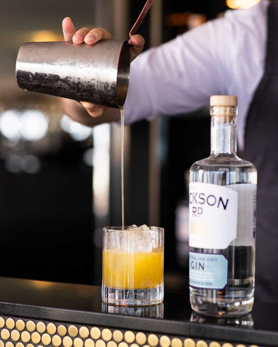 A man pours a cocktail at Hickson House Distilling Co in The Rocks, Sydney