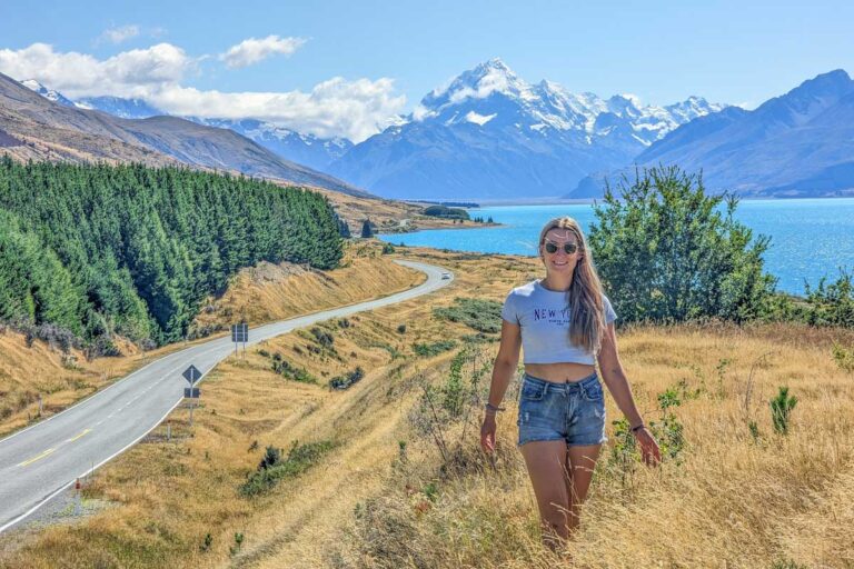 Bailey stands at a roadside viewpoint with Mount Cook in the background.
