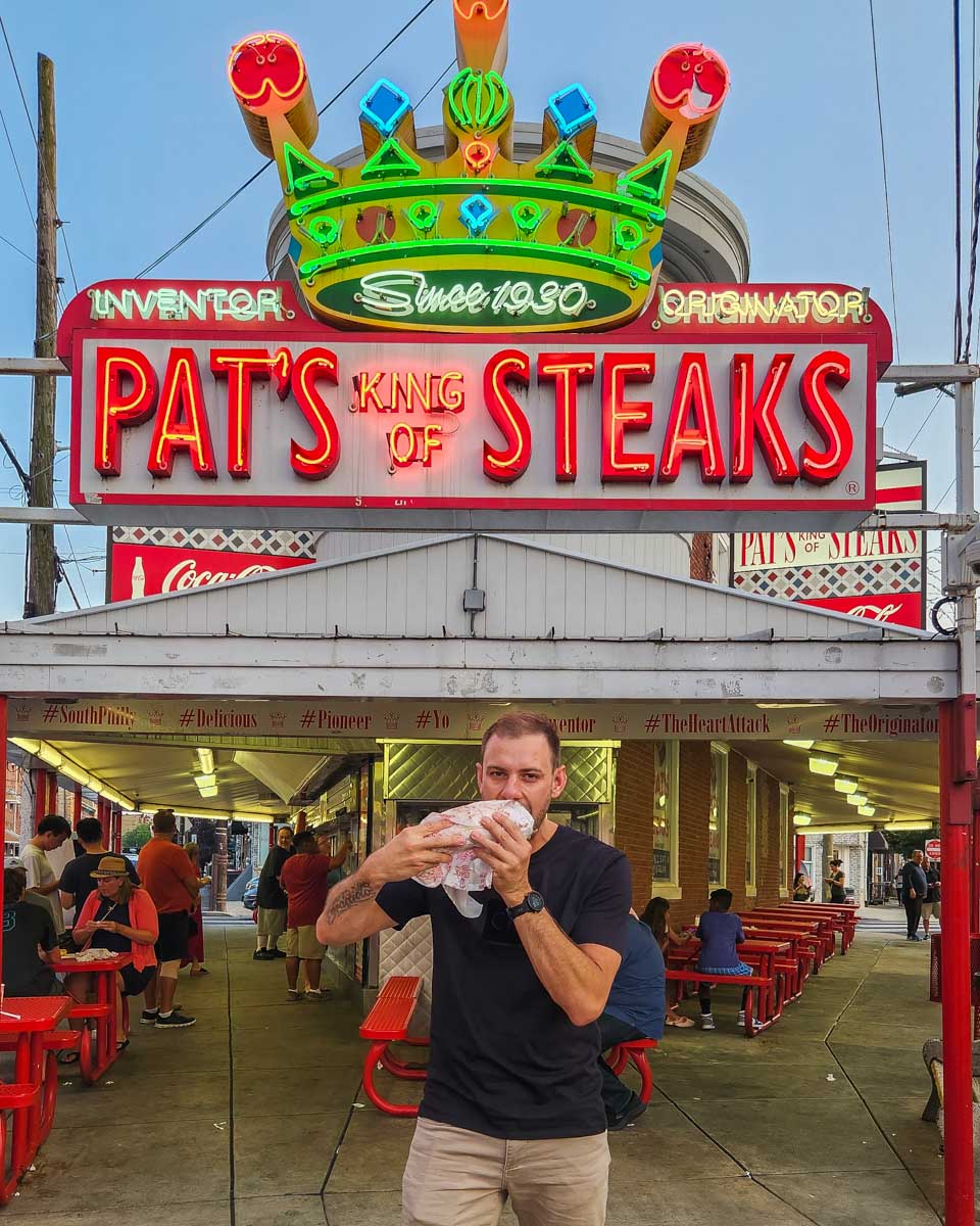 Daniel bites into a cheese steak at Pat’s King of Steaks in Philadelphia, USA