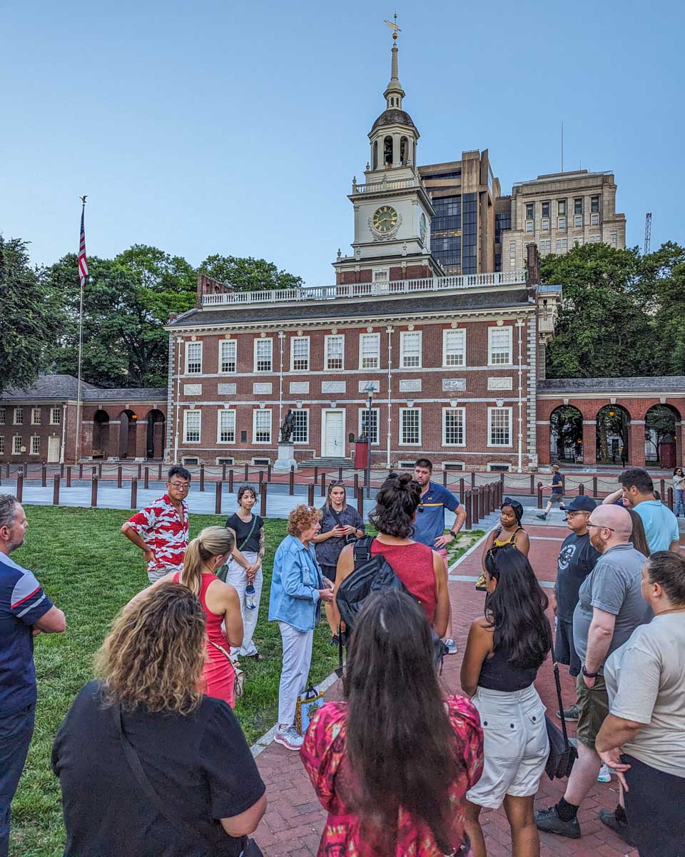 A guide talks to a group on a night tour in Philadelphia, USA